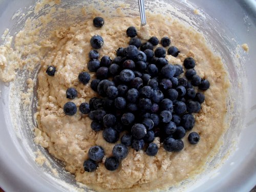 adding blueberries to muffin batter